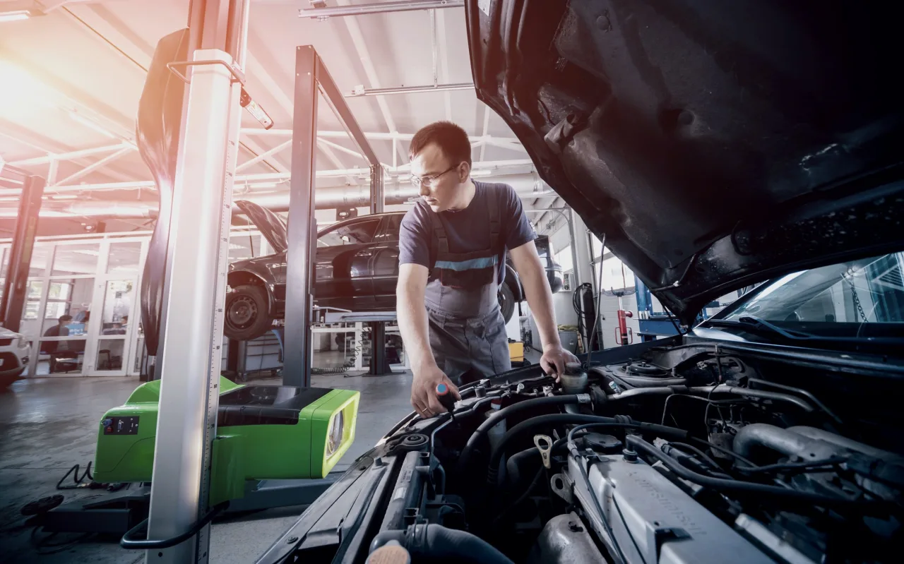 Vistoriador inspecionando o motor de um carro
